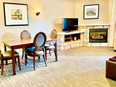 a living room with a table and chairs and a fireplace at Hillside Haven: Carriage Club Resort Retreat in Edgar