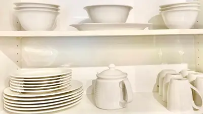 a stack of plates and bowls on a shelf in a refrigerator at Hillside Haven: Carriage Club Resort Retreat in Edgar