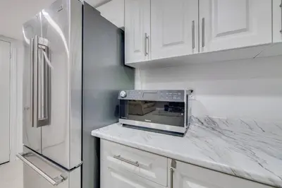 a kitchen with white cabinets and a microwave on a counter at Hidden Gem: Spacious Basement in Milton