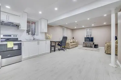 a kitchen with white cabinets and a table and chairs at Hidden Gem: Spacious Basement in Milton