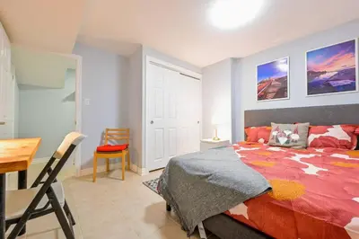 a bedroom with a bed and a table and a desk at Stylish 2BR: w/free parking & streaming! in Pickering