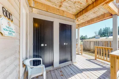 a porch with a black door and a white chair at Steps to the Hill 1 Bedroom CraveTV in Blue Mountains