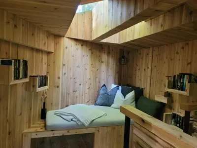 a sauna with a bed in a wooden wall at Black Pine Tree House in Acton