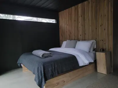 a bedroom with a large bed with a window at Black Pine Tree House in Acton