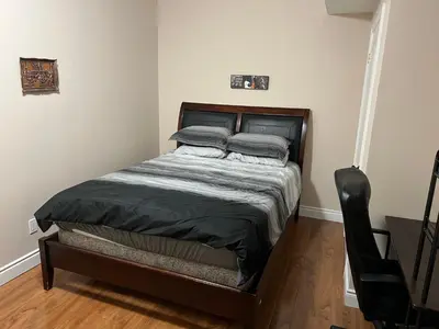 a small bed in a room with a wooden floor at 2 bedroom basement with parking in Richmond Hill