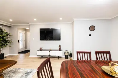 a dining room with a table and a tv on the wall at Matilda’s Luxury House in Mississauga