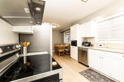 a kitchen with white cabinets and black appliances at Matilda’s Luxury House in Mississauga
