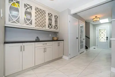 a kitchen with white cabinets and a tile floor at Serene 4BR house with Hot tub, Lake, Billiards and BBQ in Georgina