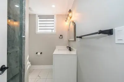 a white bathroom with a sink and a shower at Serene 4BR house with Hot tub, Lake, Billiards and BBQ in Georgina