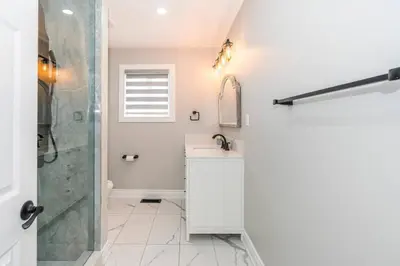 a white bathroom with a sink and a shower at Serene 4BR house with Hot tub, Lake, Billiards and BBQ in Georgina