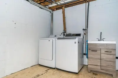 a laundry room with a refrigerator and a sink at Serene 4BR house with Hot tub, Lake, Billiards and BBQ in Georgina