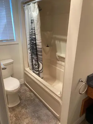 a shower curtain in a bathroom with a toilet at North of Avon B&B Suites in Stratford