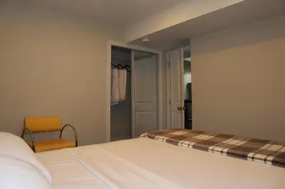 a bedroom with a bed and a chair next to a door at Stunning Furnished 2 Bedroom 2 Washroom Basement Apartment in Brampton