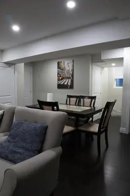 a living room with a couch and a table and chairs at Stunning Furnished 2 Bedroom 2 Washroom Basement Apartment in Brampton