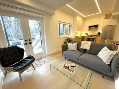 a living room with a couch and a chair at Modern Apartment Close To The Beach with Parking in Toronto