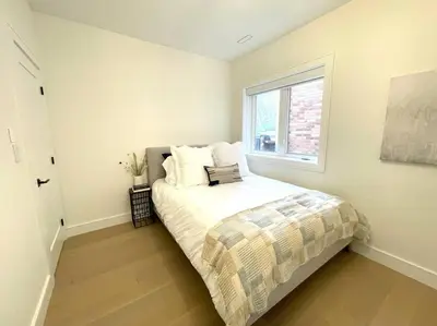 a small bedroom with a bed with a window at Modern Apartment Close To The Beach with Parking in Toronto