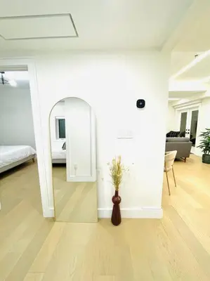 a living room with a mirror and a vase on the floor at Modern Apartment Close To The Beach with Parking in Toronto