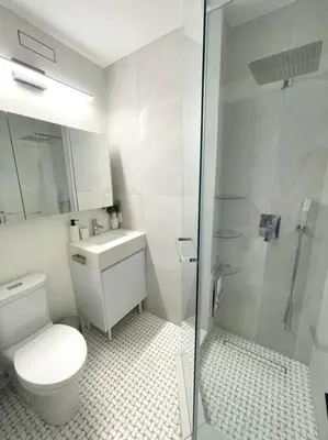 a white bathroom with a toilet and a shower at Modern Apartment Close To The Beach with Parking in Toronto