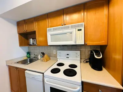 a kitchen with a white stove and a microwave at RivetStays - The Yonge in Toronto