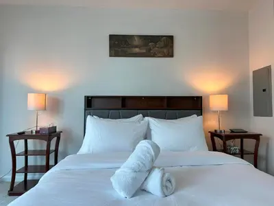 a bedroom with a white bed with towels on it at RivetStays - The Yonge in Toronto