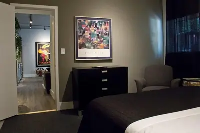 a bedroom with a bed and a dresser with a picture on the wall at Woodbine Warehouse Apartment in Toronto