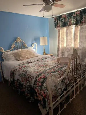 a bedroom with a bed with a floral bedspread at Comfortable Stay In Beautiful Home in Milton