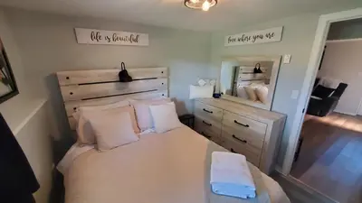 a bedroom with a bed and a dresser and a mirror at Serenity Place by the Lake in Brighton