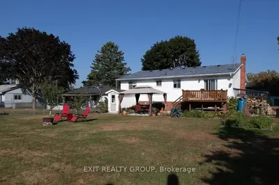a white house with a gazebo and chairs in a yard at Serenity Place by the Lake in Brighton