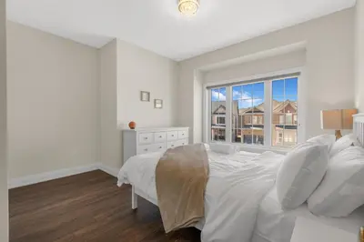 a white bedroom with a bed and a window at Executive 5BR-4BATH Detached Bramp/Miss Border in Brampton