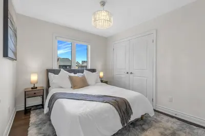 a white bedroom with a bed and a window at Executive 5BR-4BATH Detached Bramp/Miss Border in Brampton