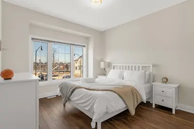 a white bedroom with a bed and a window at Executive 5BR-4BATH Detached Bramp/Miss Border in Brampton