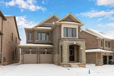 a brick house with a garage in the snow at Executive 5BR-4BATH Detached Bramp/Miss Border in Brampton