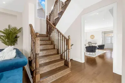 a staircase in a living room with a blue couch at Executive 5BR-4BATH Detached Bramp/Miss Border in Brampton