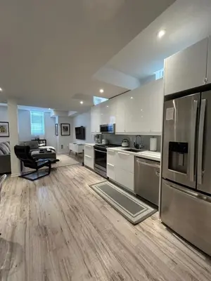 a large kitchen with white cabinets and a refrigerator at Luxury Executive Studio in Oakville