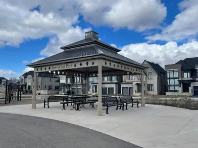 a pavilion with tables and benches in front of a building at Luxury Executive Studio in Oakville