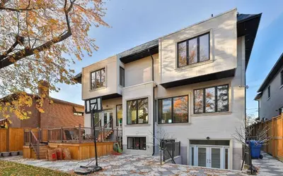 a white house with windows and a fence at Executive Room in Toronto next to Yorkdale shopping centre in Toronto