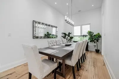 a dining room table with white chairs and a mirror at Executive Room in Toronto next to Yorkdale shopping centre in Toronto