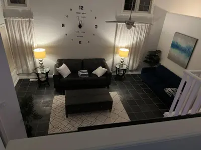 a living room with a couch and a clock on the wall at Luxury Spacious 5-Bedroom Home in London