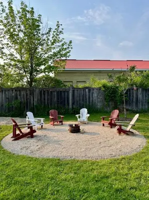 a group of chairs and tables in a yard at New and Cozy Cottage Minutes to Blue Mountain in Meaford