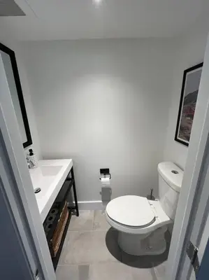 a white bathroom with a toilet and a sink at New and Cozy Cottage Minutes to Blue Mountain in Meaford