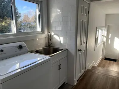 a white kitchen with a sink and a window at New and Cozy Cottage Minutes to Blue Mountain in Meaford