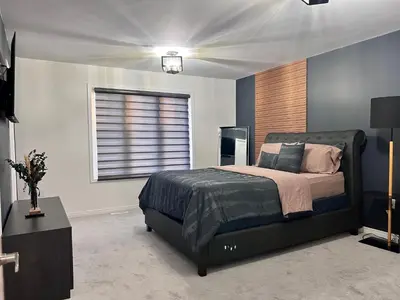 a bedroom with a large bed and a window at Spacious 4-Bedroom Home, Comfortably Sleeps 10 in Barrie