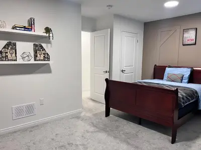 a bedroom with a bed and a book shelf at Spacious 4-Bedroom Home, Comfortably Sleeps 10 in Barrie