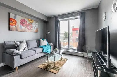 a living room with a couch and a tv at Glenview West Apartment w Patio - Near Downtown in Hamilton