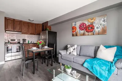 a living room with a couch and a kitchen at Glenview West Apartment w Patio - Near Downtown in Hamilton