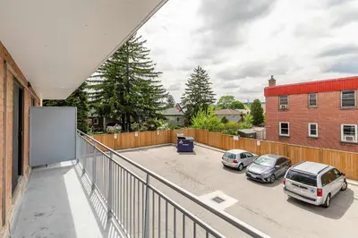 a balcony with cars parked in a parking lot at Glenview West Apartment w Patio - Near Downtown in Hamilton