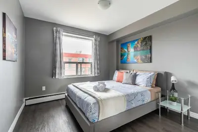 a bedroom with a large bed and a window at Glenview West Apartment w Patio - Near Downtown in Hamilton
