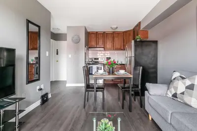 a kitchen and living room with a table and a couch at Glenview West Apartment w Patio - Near Downtown in Hamilton