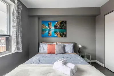 a bedroom with a bed and a painting on the wall at Glenview West Apartment w Patio - Near Downtown in Hamilton