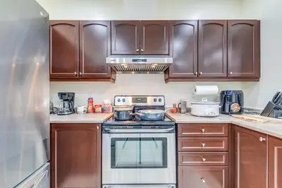 a kitchen with wooden cabinets and a stove top oven at Avid vacation palace in Castlemore , Brampton in Brampton
